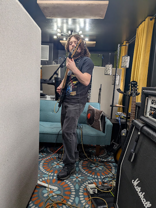 A drummer recording behind acoustic panels