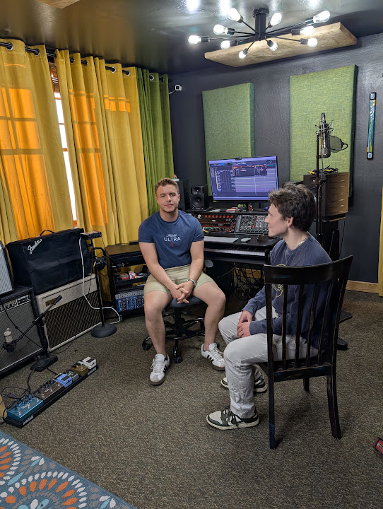 Two collaborators in front of the studio console