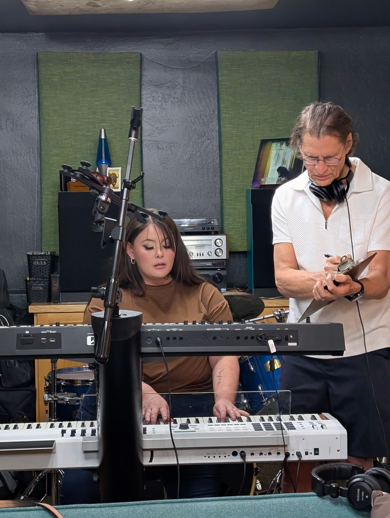A keyboard player and producer preparing a part in the live room