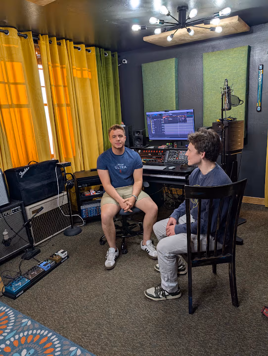 Two collaborators in front of the studio console